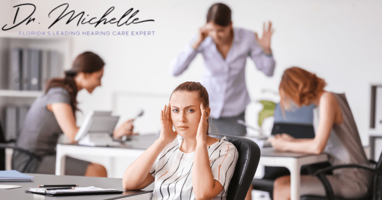 woman holding her ears in her workplace