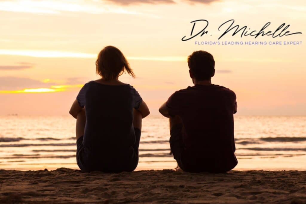 couple sitting on the beach watching the sunset