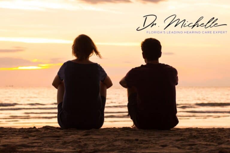 couple sitting on the beach watching the sunset